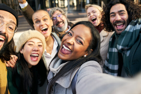 Business woman taking selfie outdoors with a group of diverse colleague people. Smiling cheerful happy photo of a co-workers outdoors. High quality photo