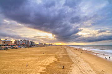 Beautiful seaside landscape - view of the beach near the embankment of The Hague with people making...