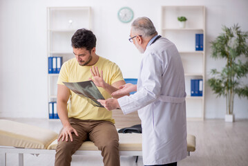Fototapeta premium Young male patient visiting old male doctor radiologist