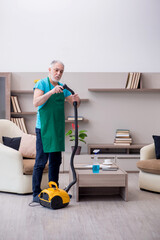 Old male contractor cleaning the house