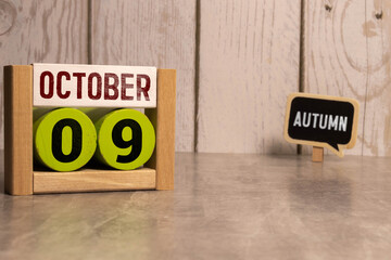 Cube shape calendar for October 09 on wooden surface with empty space for text.