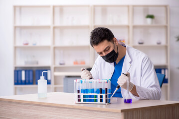 Young male chemist working at the lab