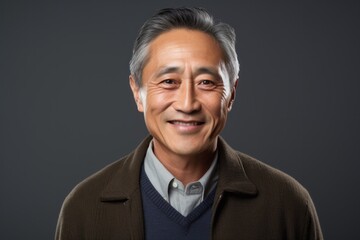 Obraz premium Portrait photography of a cheerful Vietnamese man in his 50s against a black background
