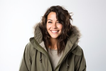 Lifestyle portrait photography of a Italian woman in her 30s wearing a warm parka against a white background