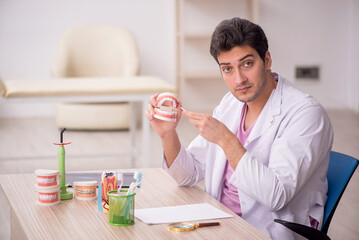 Young male dentist working in the clinic