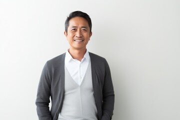 Lifestyle portrait photography of a Vietnamese man in his 40s against a minimalist or empty room background