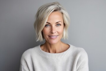 Medium shot portrait photography of a Swedish woman in her 40s wearing a cozy sweater against a minimalist or empty room background