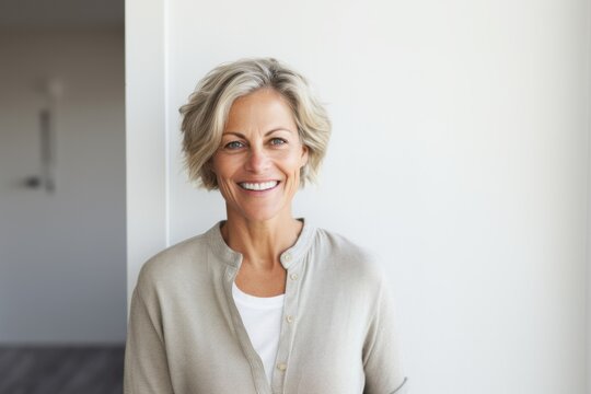 Lifestyle portrait photography of a Swedish woman in her 50s against a minimalist or empty room background