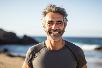 Portrait photography of a Colombian man in his 50s wearing a pair of leggings or tights against a beach background