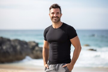 Lifestyle portrait photography of a Italian man in his 30s wearing a pair of leggings or tights against a beach background