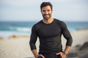Fototapeta premium Lifestyle portrait photography of a Italian man in his 30s wearing a pair of leggings or tights against a beach background