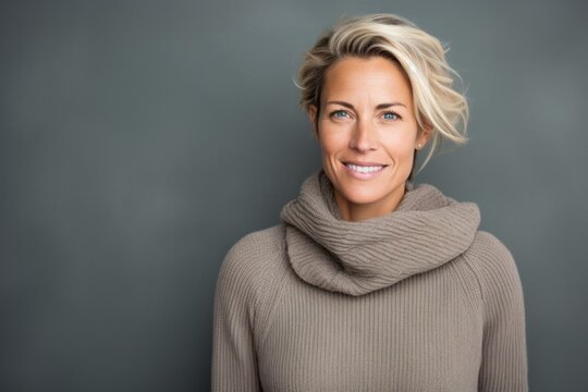 Portrait photography of a Swedish woman in her 40s wearing a cozy sweater against an abstract background