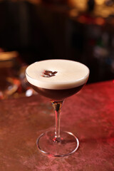 Glass of delicious Espresso Martini on bar counter. Alcoholic cocktail