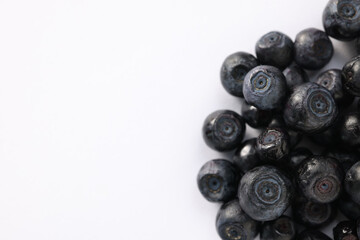 Pile of ripe bilberries on white background, closeup. Space for text