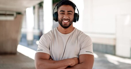 Face, fitness and music with a man arms crossed in the city for cardio training or marathon preparation. Portrait, smile and music with a happy young athlete in an urban town for a summer workout