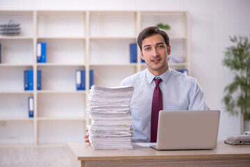 Young male employee and too much work in the office