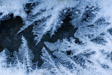 Overhead view of ice forming over a flowing stream.