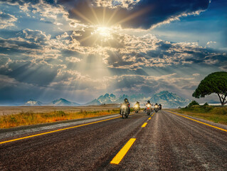 Group of bikers riding on the highway, at sunset, mountains behind, freedom concept