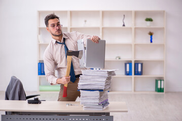 Young male employee unhappy with excessive work in the office