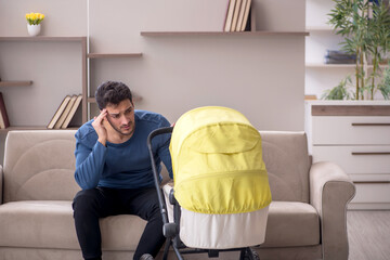 Young male contractor looking after baby at home