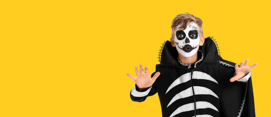 Little boy in Halloween costume on yellow background with space for text