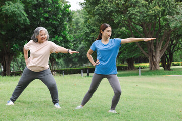 senior asian with trainer doing exercises in the park at home. healthy lifestyle concept.