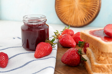 Jar of sweet strawberry jam on table