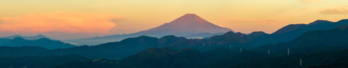 山岳地帯から撮影した朝日を浴びて赤くなる富士山