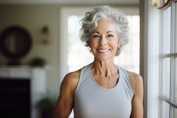 Portrait of a happy and smiling senior woman wearing sports clothes inside of her home