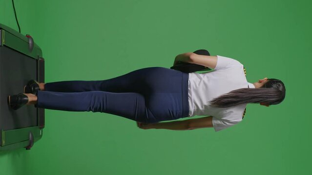 Back View Full Body Of Asian Woman Pilot Walking On Treadmill In The Green Screen Background Studio
