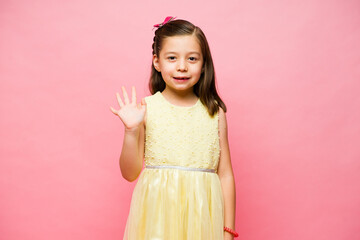 Happy elementary kid saying goodbye and smiling