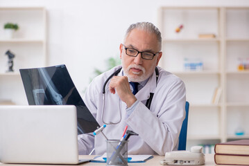 Old male doctor radiologist working in the clinic