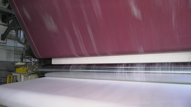 The machinery in a paper mill plant. Paper production machine in waste paper recycling factory. Paper and pulp mill.
