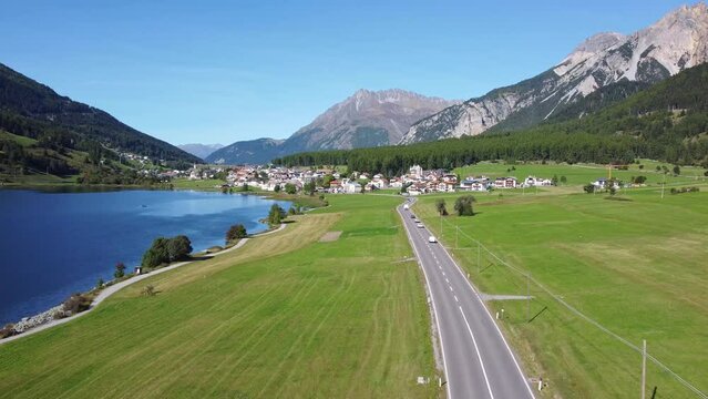 Aerial drone footage of the road along the Resia lake in the alps in northern Italy in Bolzano South Tyrol province just before the Austrian border on a sunny summer day 
