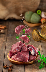 Raw meat slices with parsley on wooden background, flying meat 