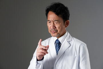 考える中年の医師　黒背景