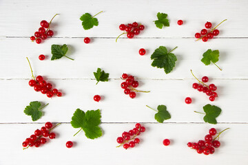Red currant pattern with green leaves on white wooden board, summer fruits, summer berries pattern