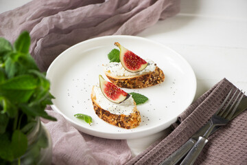 Healthy sandwiches with fresh figs and cream cheese, mint leaves, white  plate, white background, healthy eating, healthy sandviches