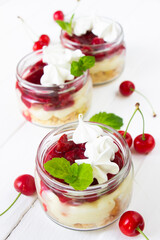 Cherry trifles. Dessert whith cherries , mint leaves and meringue in a glass
