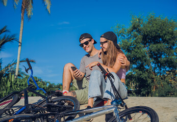 Young happy couple with BMX taking selfie at the skatepark