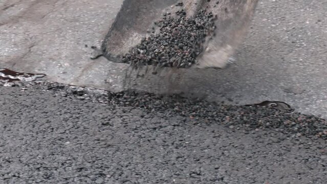 Street resurfacing. Fresh asphalt construction. WorkMen filling Pot Holes.  Traffic surface improvement By paving asphalt
