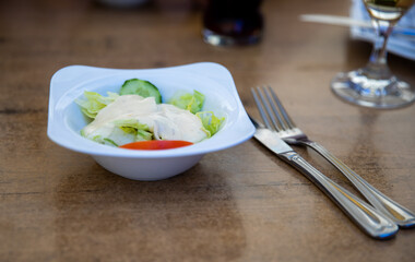 Ein kleiner Salat mit Dressing beim Griechen auf dem Tisch als Vorspeise