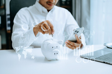 Asian Man are putting coins in a piggy bank for a business that grows for profit and saving money...