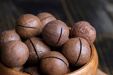 Unpeeled macadamia nuts on a wooden table