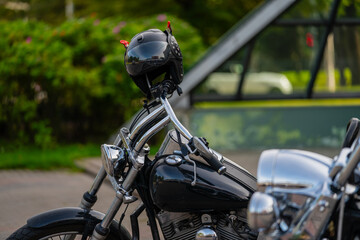 Fototapeta na wymiar Helmet hanging on modern style black chopper type motorcycle for bikers