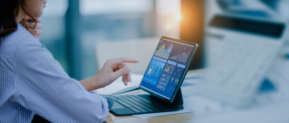 Technology and financial advisory services concept. Businesswoman working on digital laptop computer with advisor showing plan of investment to clients at table office. Digital marketing.