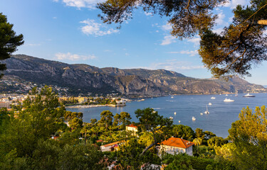Panoramic view of Saint-Jean-Cap-Ferrat resort town on Cap Ferrat cape with exclusive estates and Alpes at French Riviera of Mediterranean Sea in France