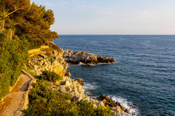 Rocky shoreline landscape of Saint-Jean-Cap-Ferrat resort town with sightseeing path on Cap Ferrat...