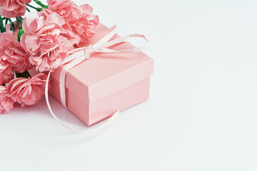 Pink gift box with tender pink carnation flowers. Gift or holiday concept. Mothers Day, birthday wedding or St Valentines day with copy space. Minimal