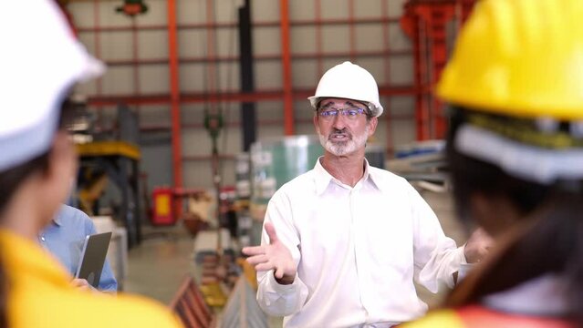 4k video slow motion, Senior engineer Meeting and explaining, training, discussing and assigning work to teams of technicians and workers in the morning before starting work in the industrial factory.